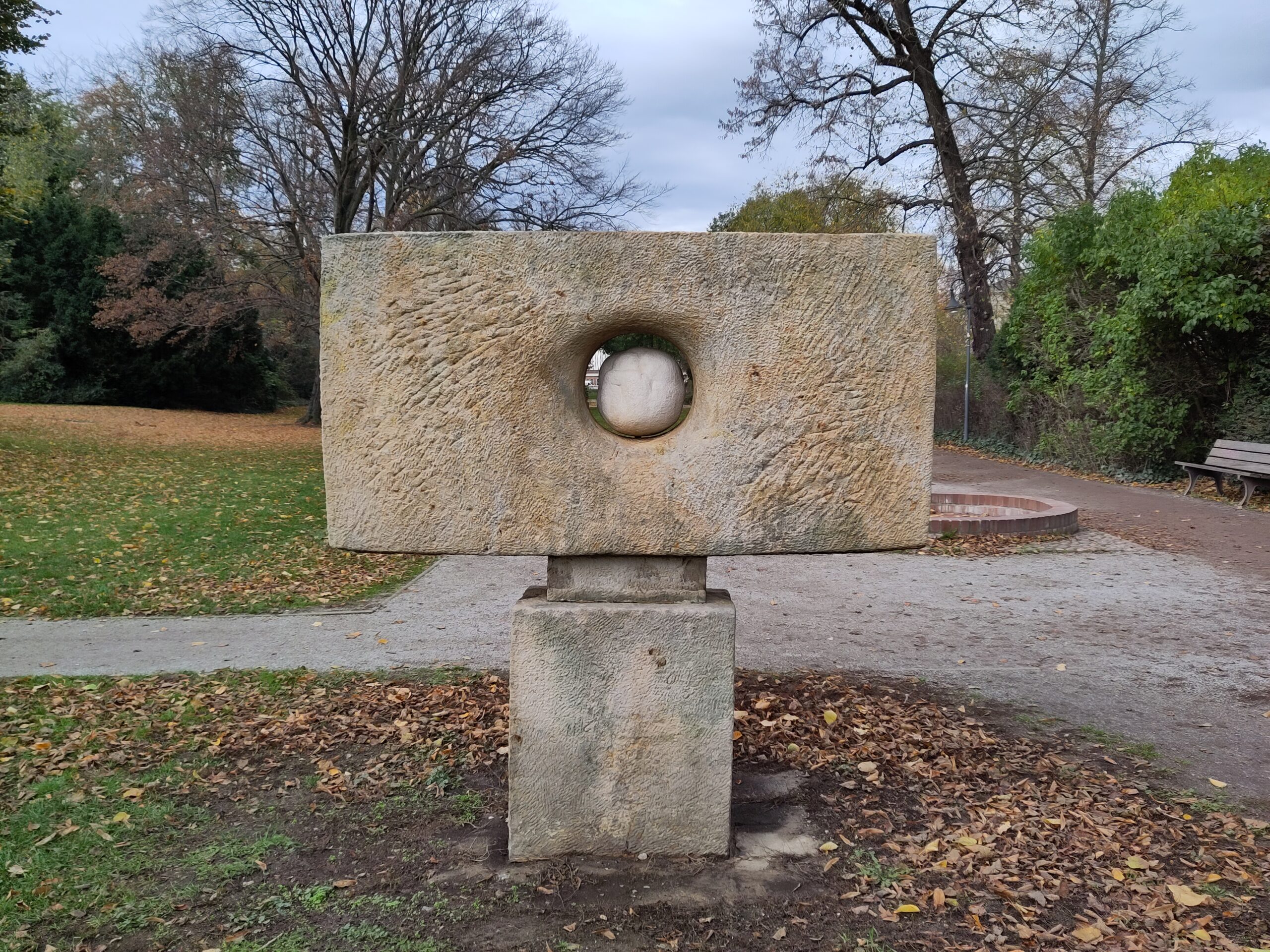 Zu sehen ist der Puschkinpark in Cottbus. Im Vordergrund steht eine Skulptur.