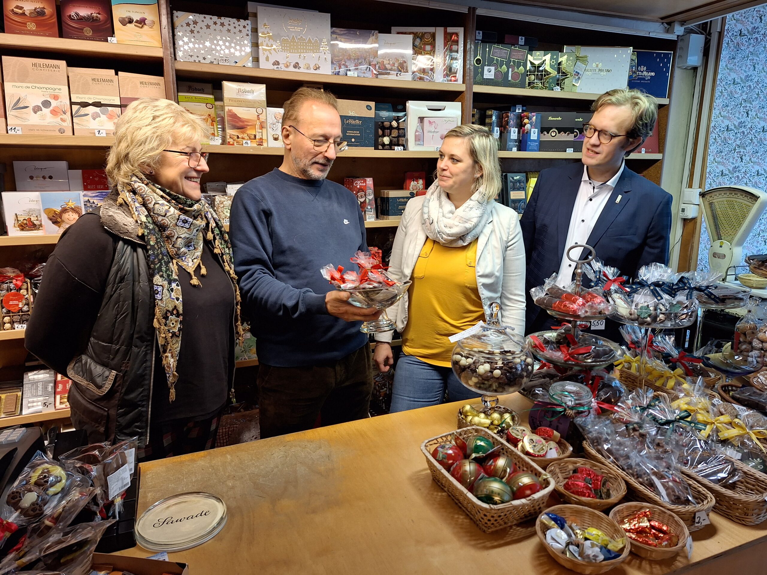 Andreas Pfeifer Wirtschaft Vier Menschen stehen vor einer Verkaufsfläche
