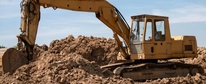 Ein Bagger steht im Sand