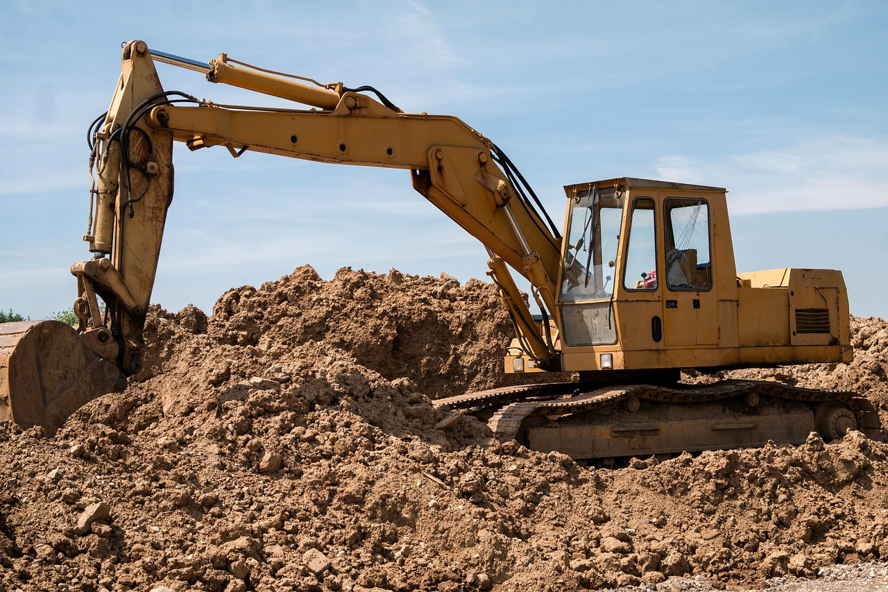 Ein Bagger steht im Sand