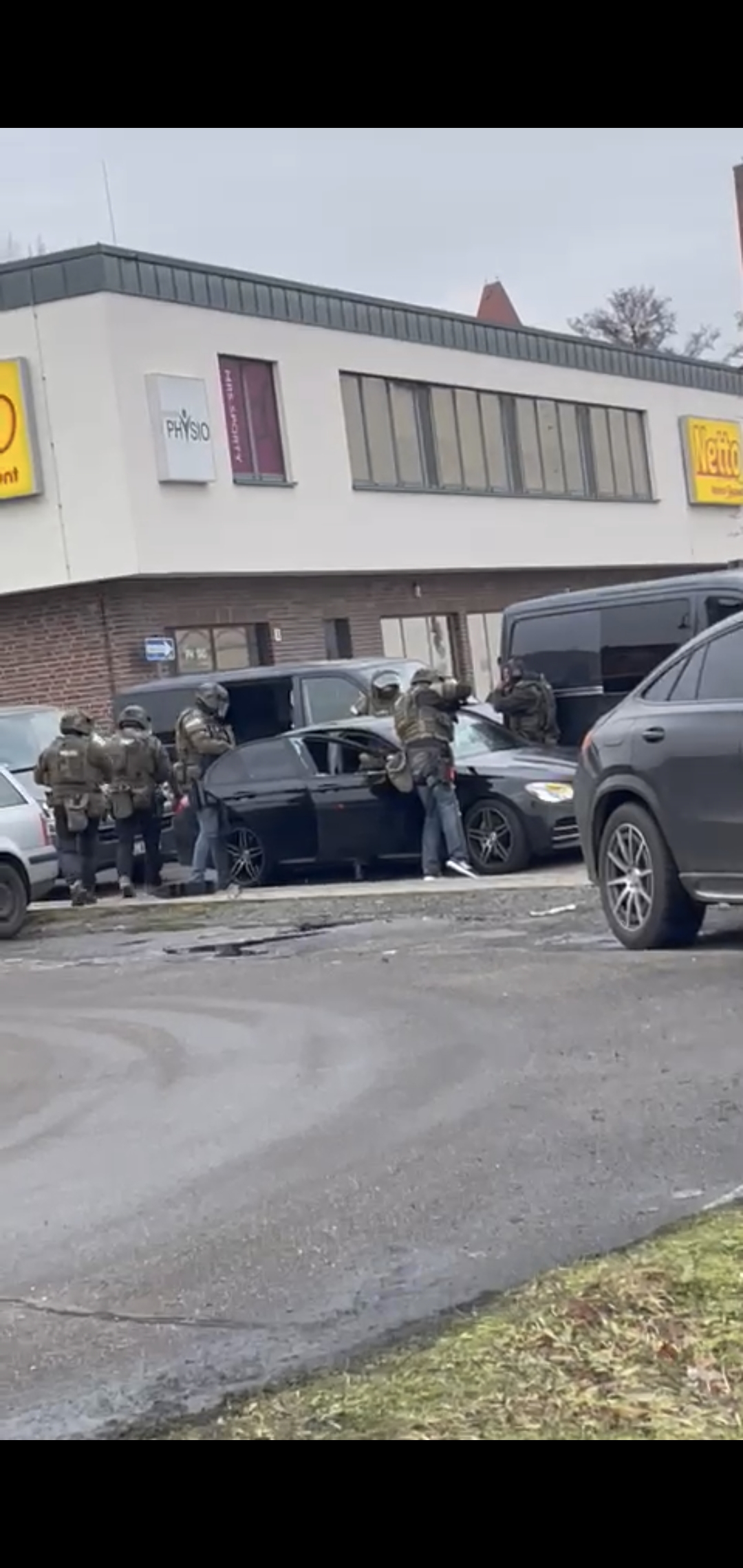 Polizisten in Schutzuniform halten ein Auto an.