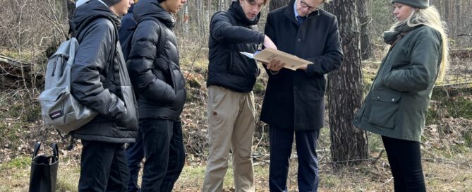 Das Foto zeigt mehrere junge Menschen mit dem Bürgermeister. Sie sprechen über Forschungsergebnisse zum Holocaust.