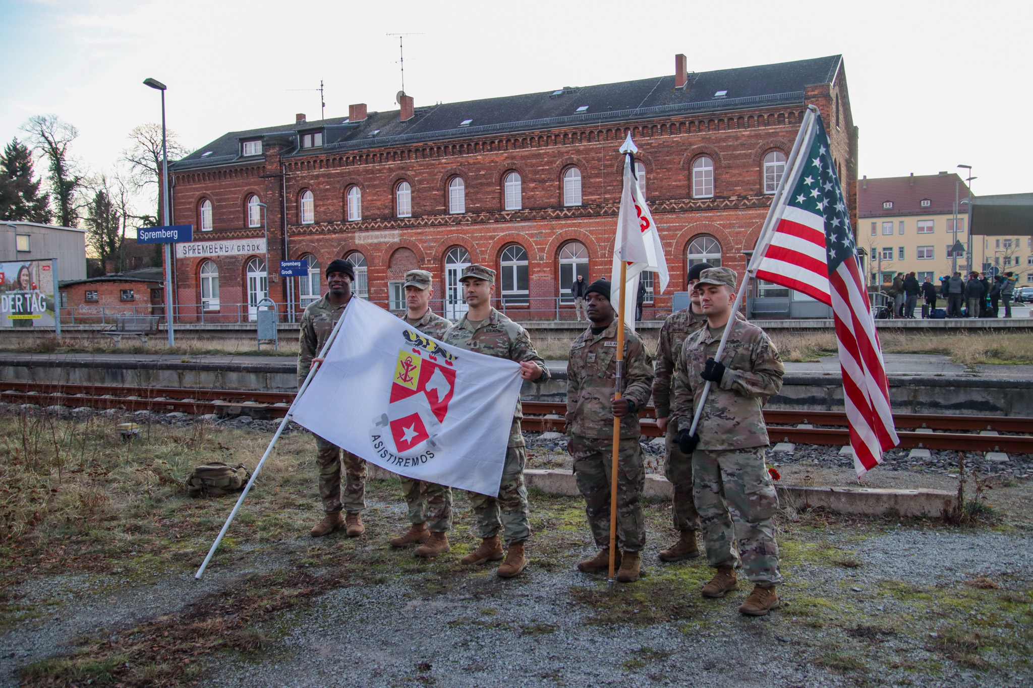 Soldaten stehen mit einer amerikanischen Flagge vor dem Güterbahnhof Spremberg