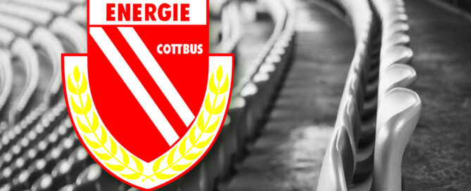 Das Bild zeigt das Logo des FC Energie Cottbus und leere Sitze im Stadion.