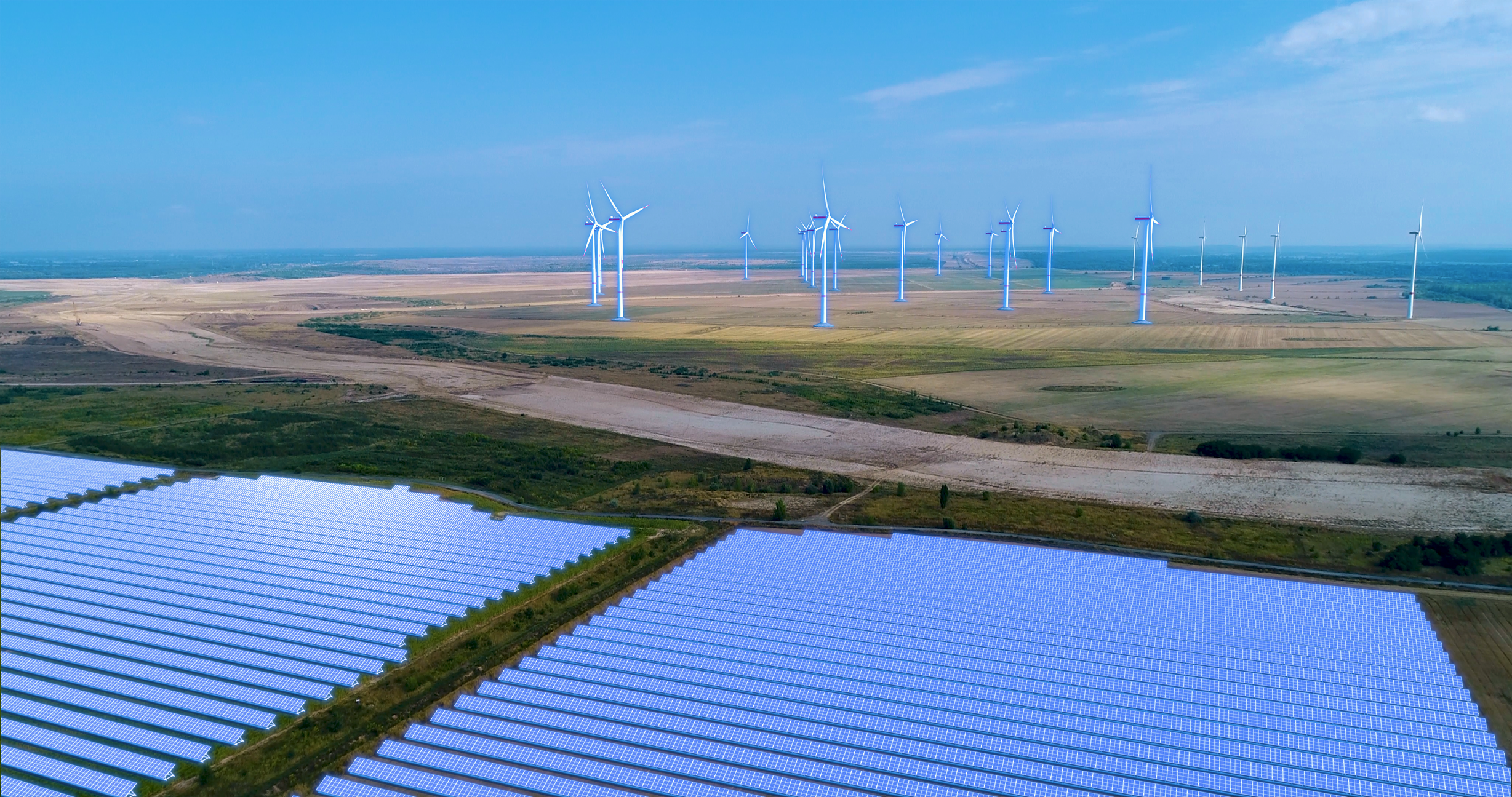 Preview_Forst-BriesnigII_EP_Bohrau_EE_Landschaft_kl (1) Windräder stehen im Hintergrund. Im Vorderfeld sind Solaranlagen zu sehen.