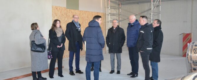 Menschen stehen in einer Halle die gerade neugebaut wird