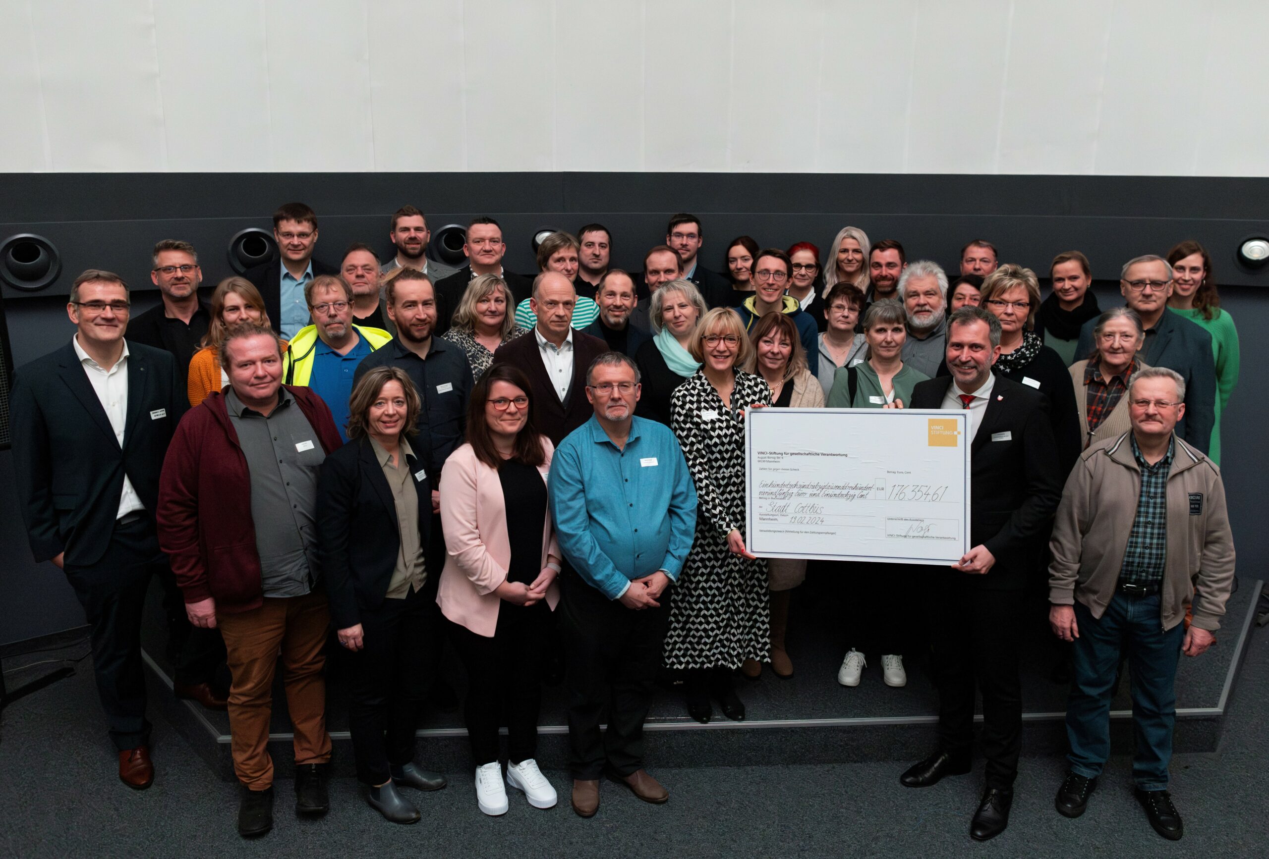VINCI_Stiftung_Cottbus_neu Menschen stehen nebeneinander und bekommen Schecks.