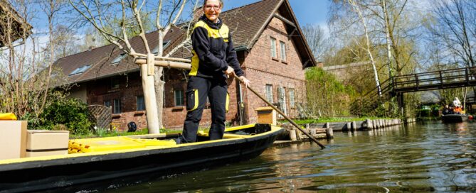 Fließ im Spreewald. Auf dem Kahn steht eine Postfrau