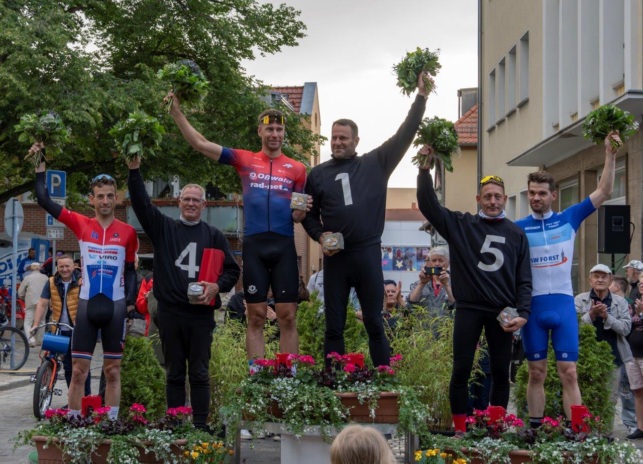 Derny Cup Jubelnde Menschen die auf dem Treppchen stehen