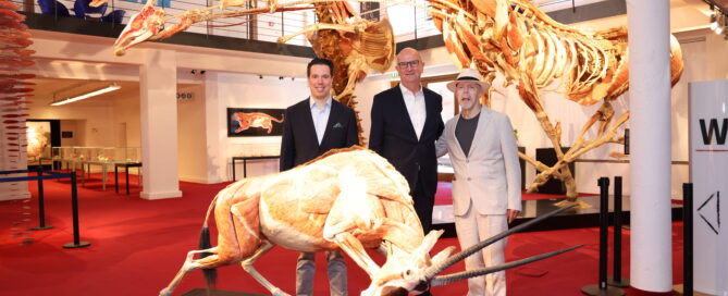 Ministerpräsident Dietmar Woidke mit Gunther und Rurik von Hagens vor einem Plastinat eines Ziegenbocks.