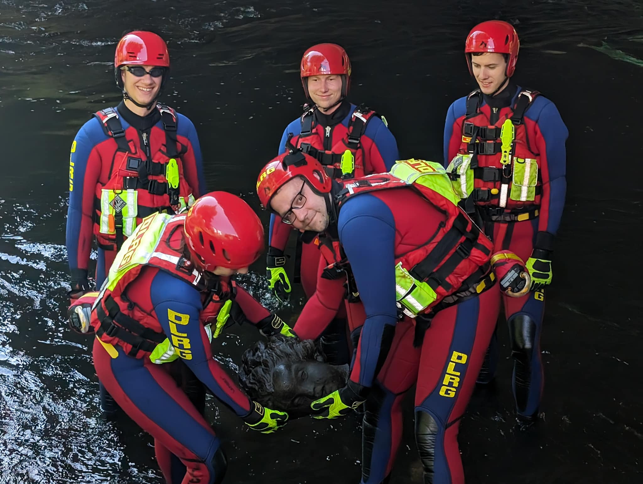 Schneckenreiter DLRG Rettungskräfte sind im Wasser. Sie halten in der Hand eine Skulptur