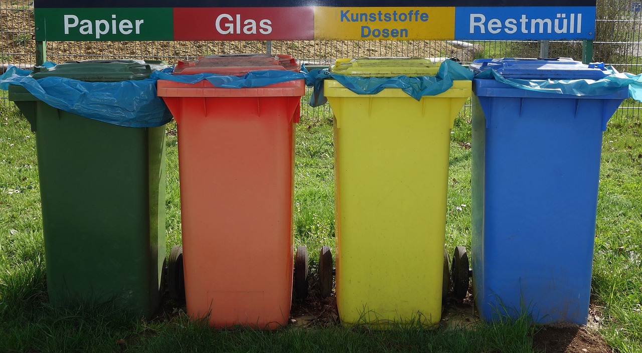 Grüne, braune, gelbe, blaue Mülltonnen stehen nebeneinander