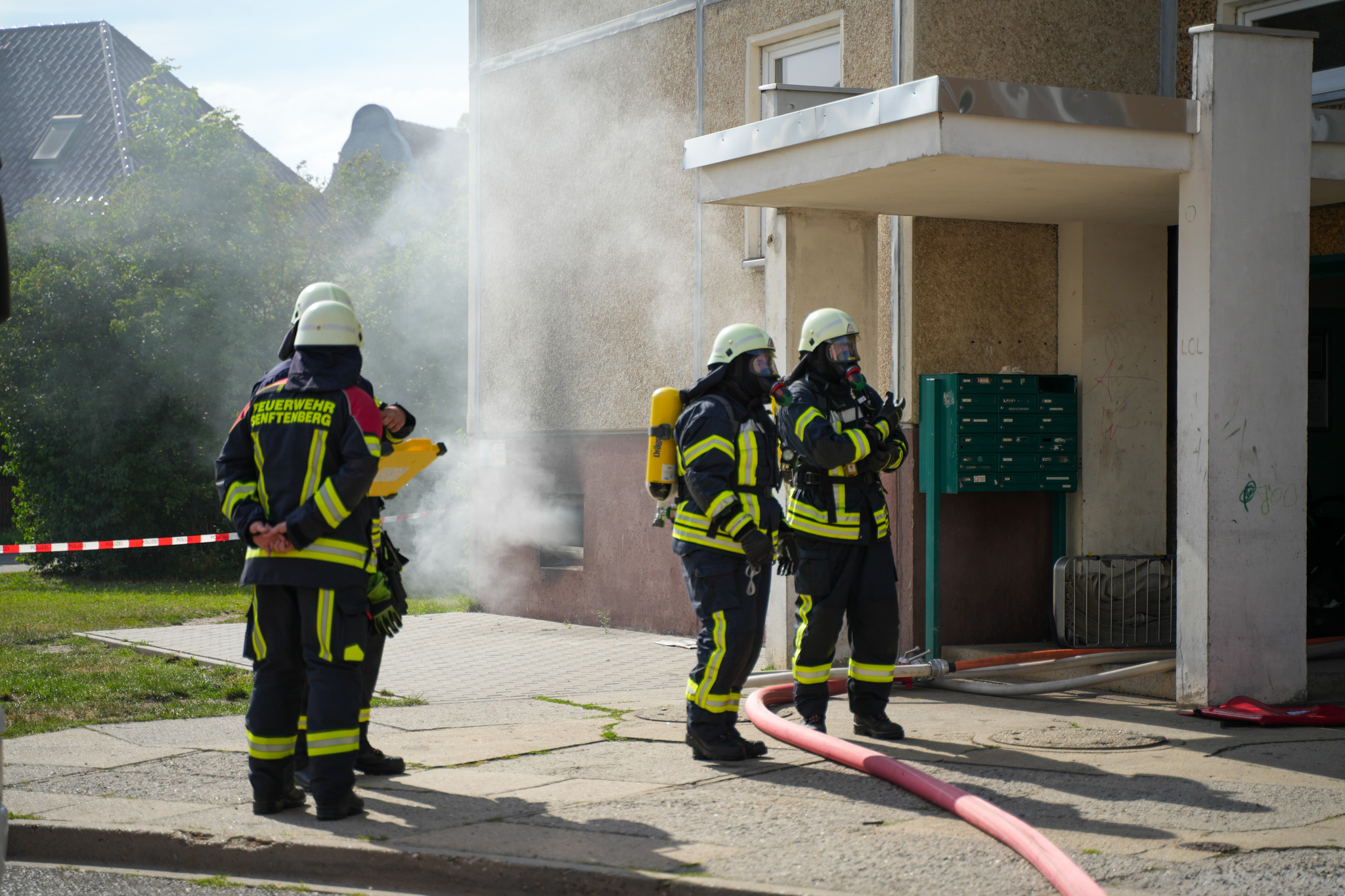 20240718_Brand_Senftenberg-18 Das Foto zeigt Feuerwehrleute mit Atemschutz im Einsatz bei einem Kellerbrand in Senftenberg.