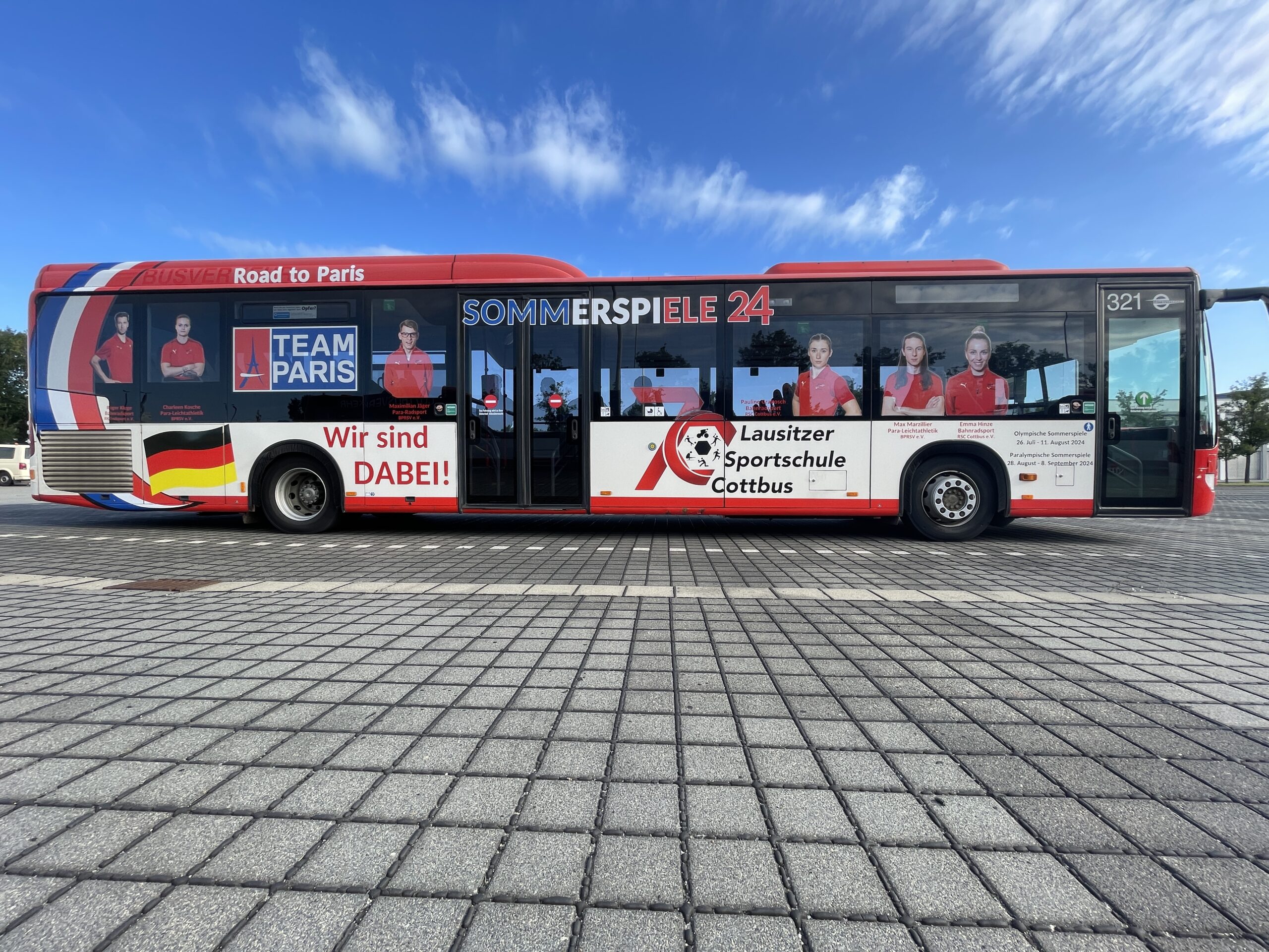 olympia bus Das Foto zeigt einen Bus von Cottbusverkehr, der mit den Gesichtern der Olympia-Teilnehmer bedruckt ist.