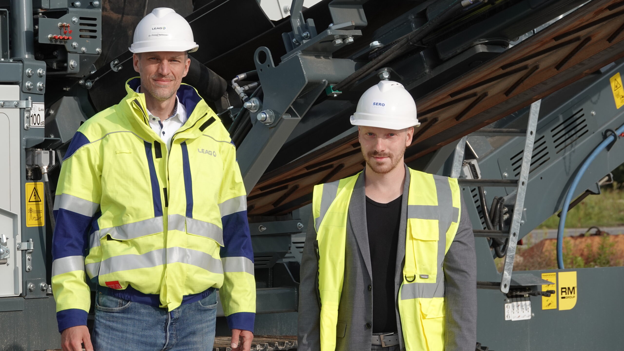 LEAG Das Foto zeigt zwei Mitarbeitende im SERO-Werk mit Warnweste und Helm.