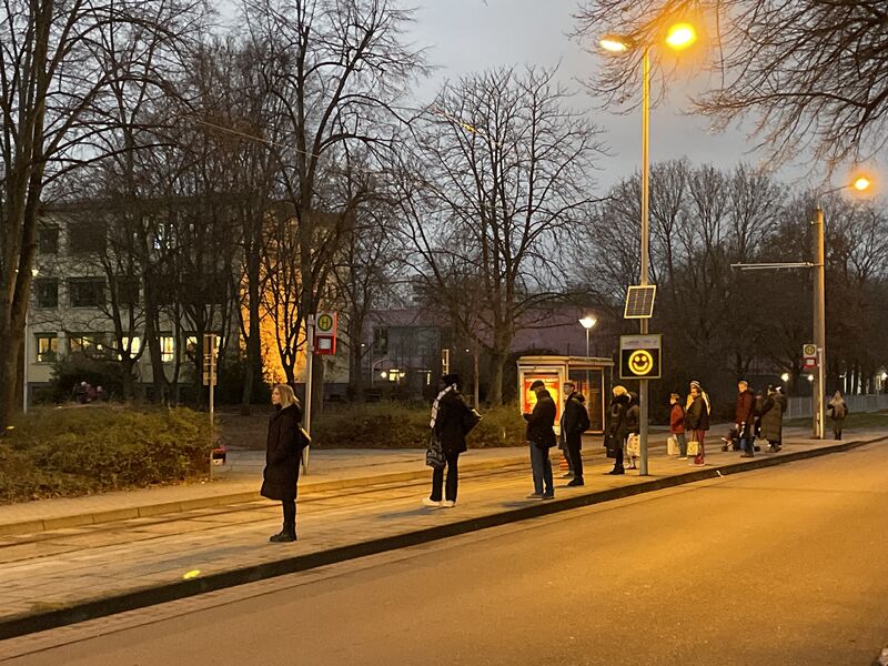 popup Bild von einer Straße, Menschen stehen an der Haltestelle