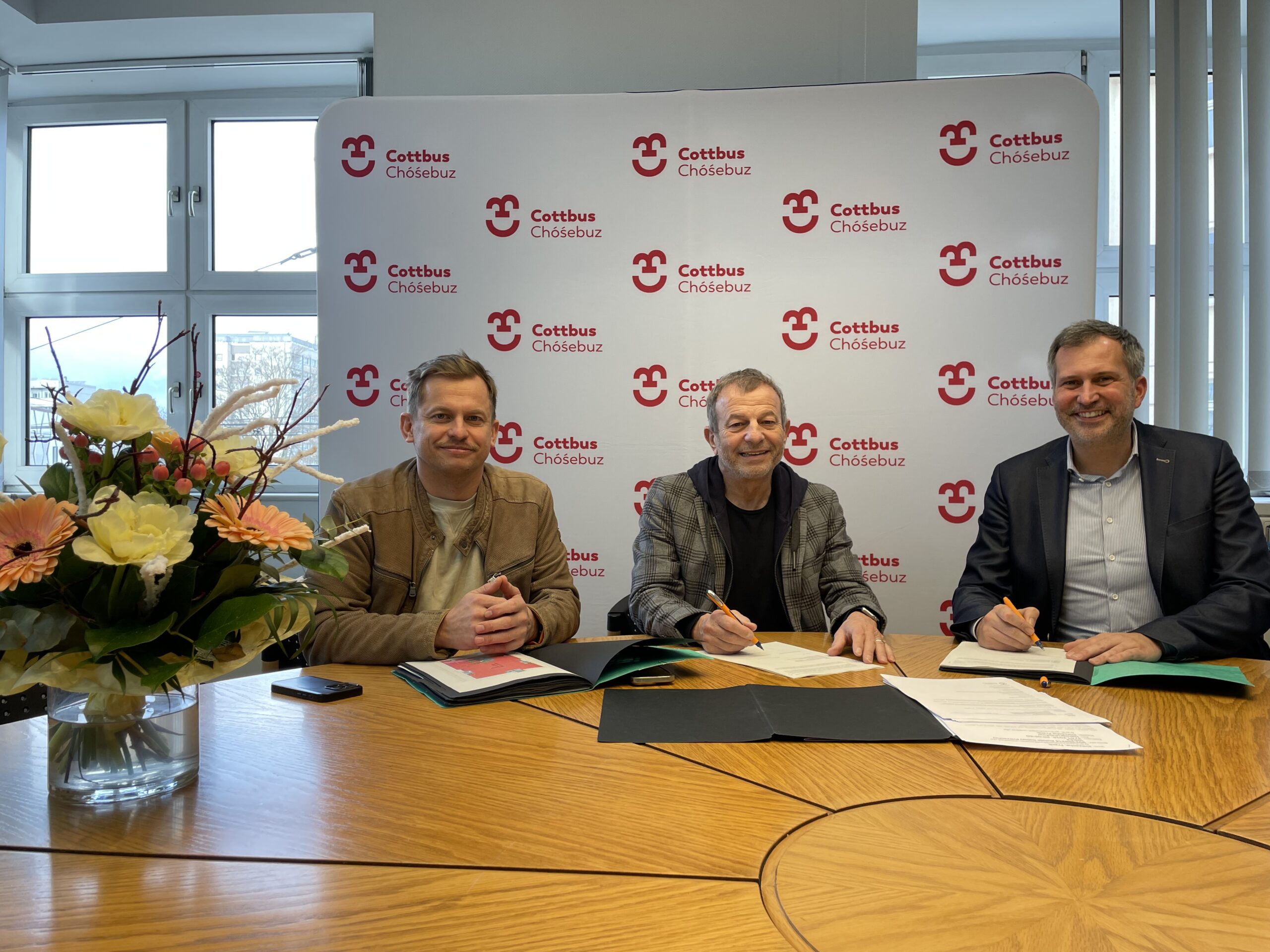 Vertragsunterzeichnung am Tisch mit Hoffmann-Möbel und der Stadt Cottbus