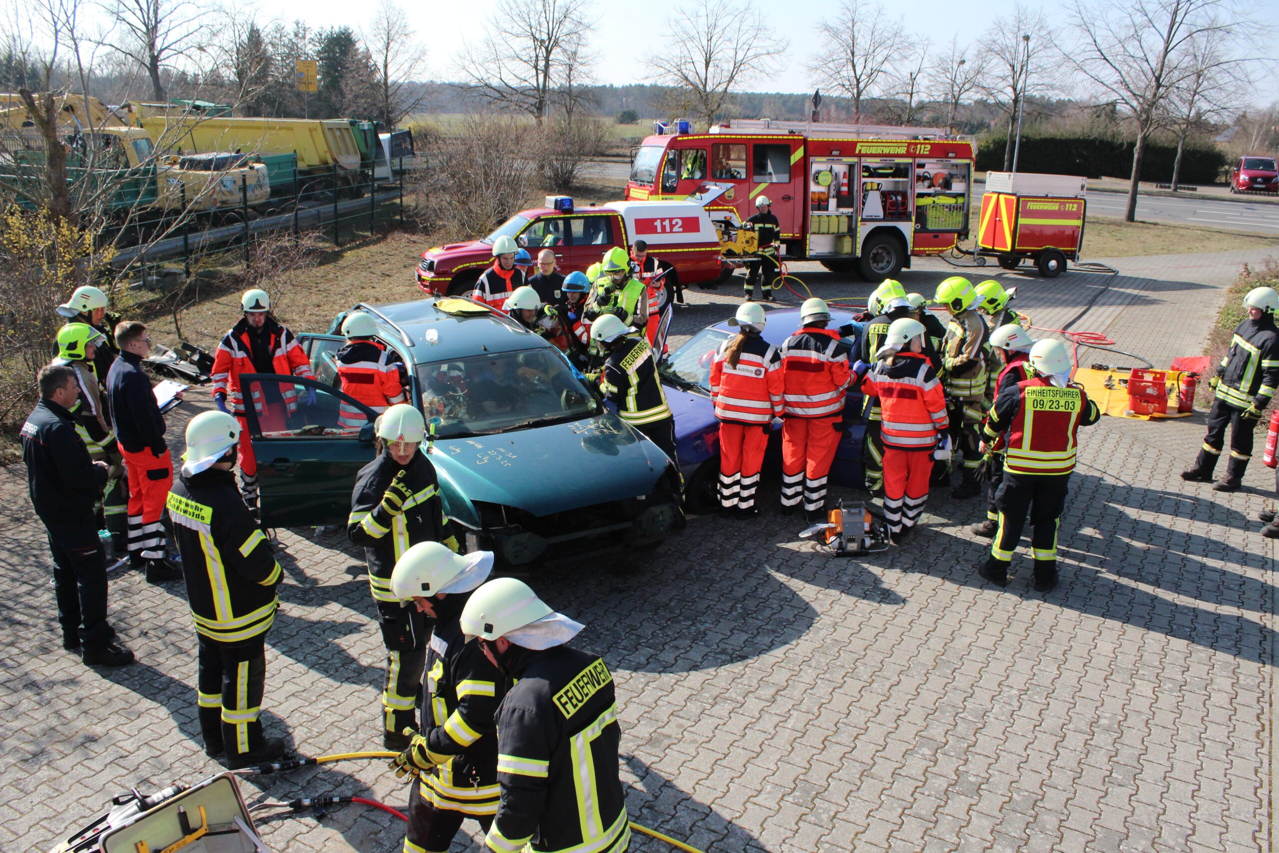 Gemeinsamer Ausbildungstag Bild 1 Ein Unfall wird simuliert. Um das Auto herum stehen viele Helfer