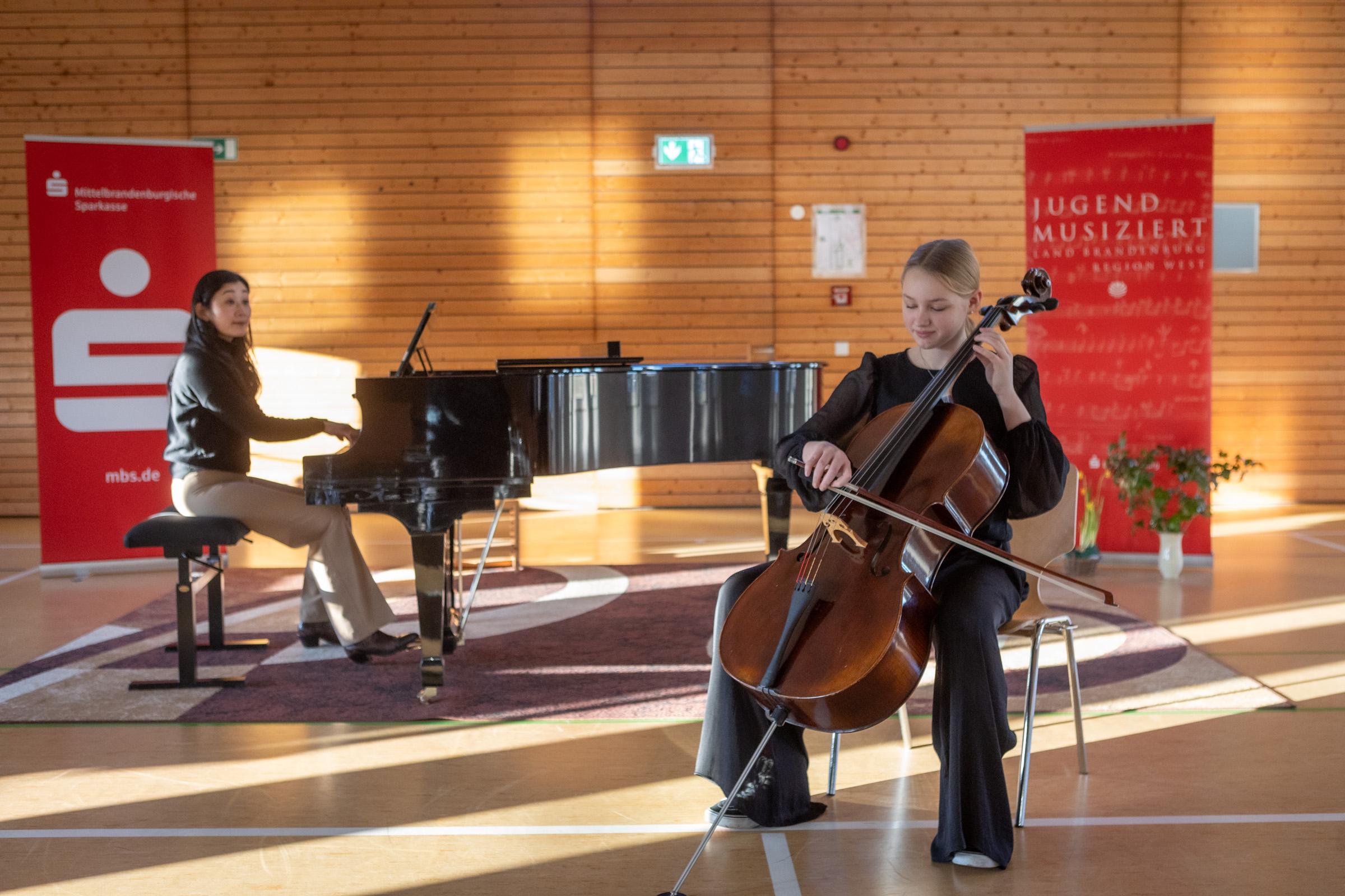 Das Bild zeiht 2 Schüler die am Instrument spielen