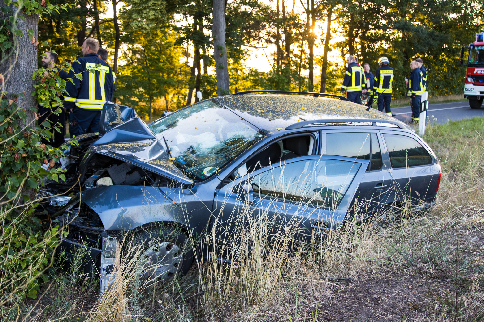 2025-06-22_TödlicherVerkehrsunfallGuhrow-01 Das Foto zeigt ein stark beschädigtes Unfallauto, das gegen einen Baum geprallt ist.