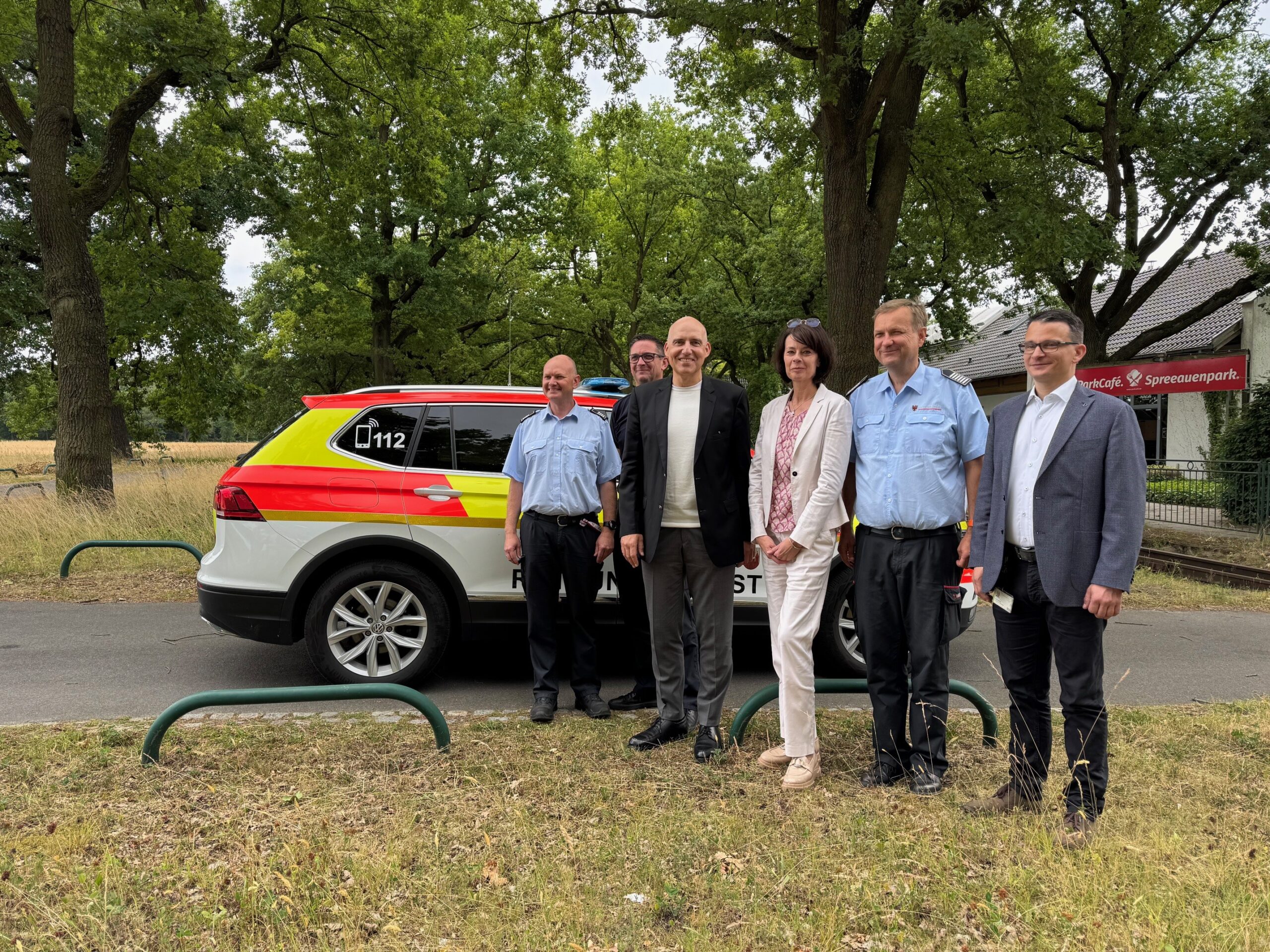MANV_2 Vor dem Auto stehen mehrere Menschen