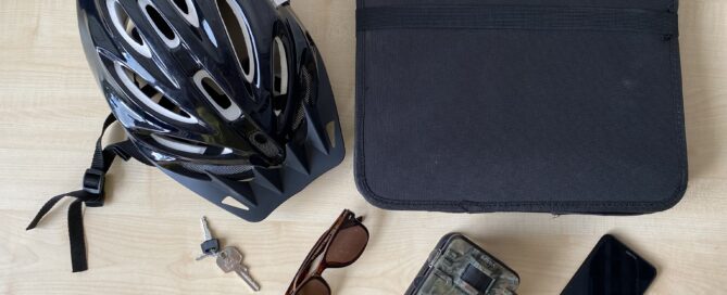 Auf dem Tisch liegen eine Sonnenbrille, ein Helm und weitere Gegenstände
