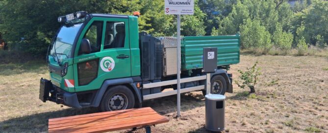 Auf dem Bild ist eine Bank und ein Transporter zu sehen