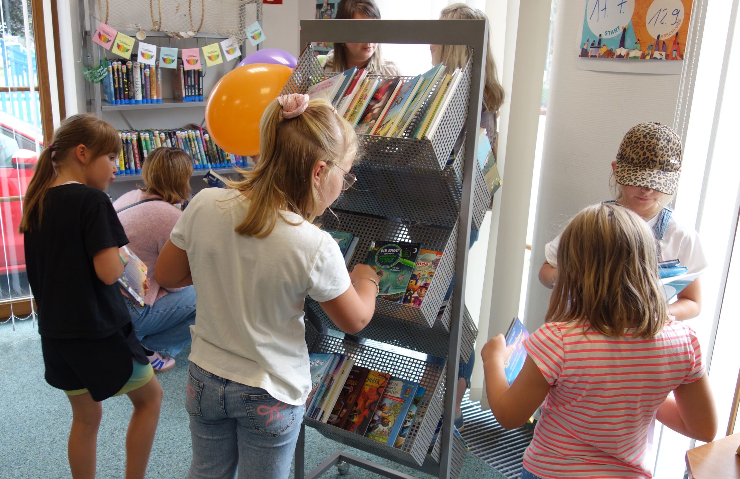 Lesesommer in der Spreewaldbibliothek_Foto K. Möbes Kinder durchwühlen Bücherecke