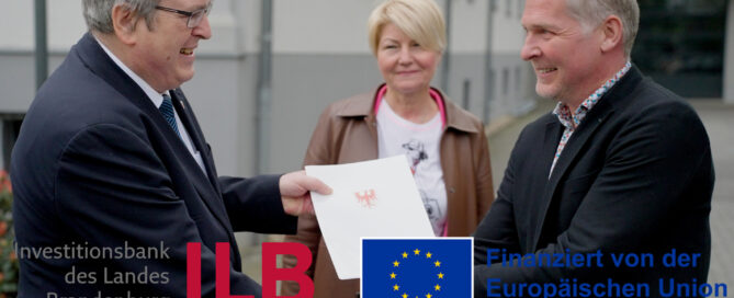 Ein Handwerksunternehmen erhält einen Förderbescheid. Mit Logos der ILB und der EU.