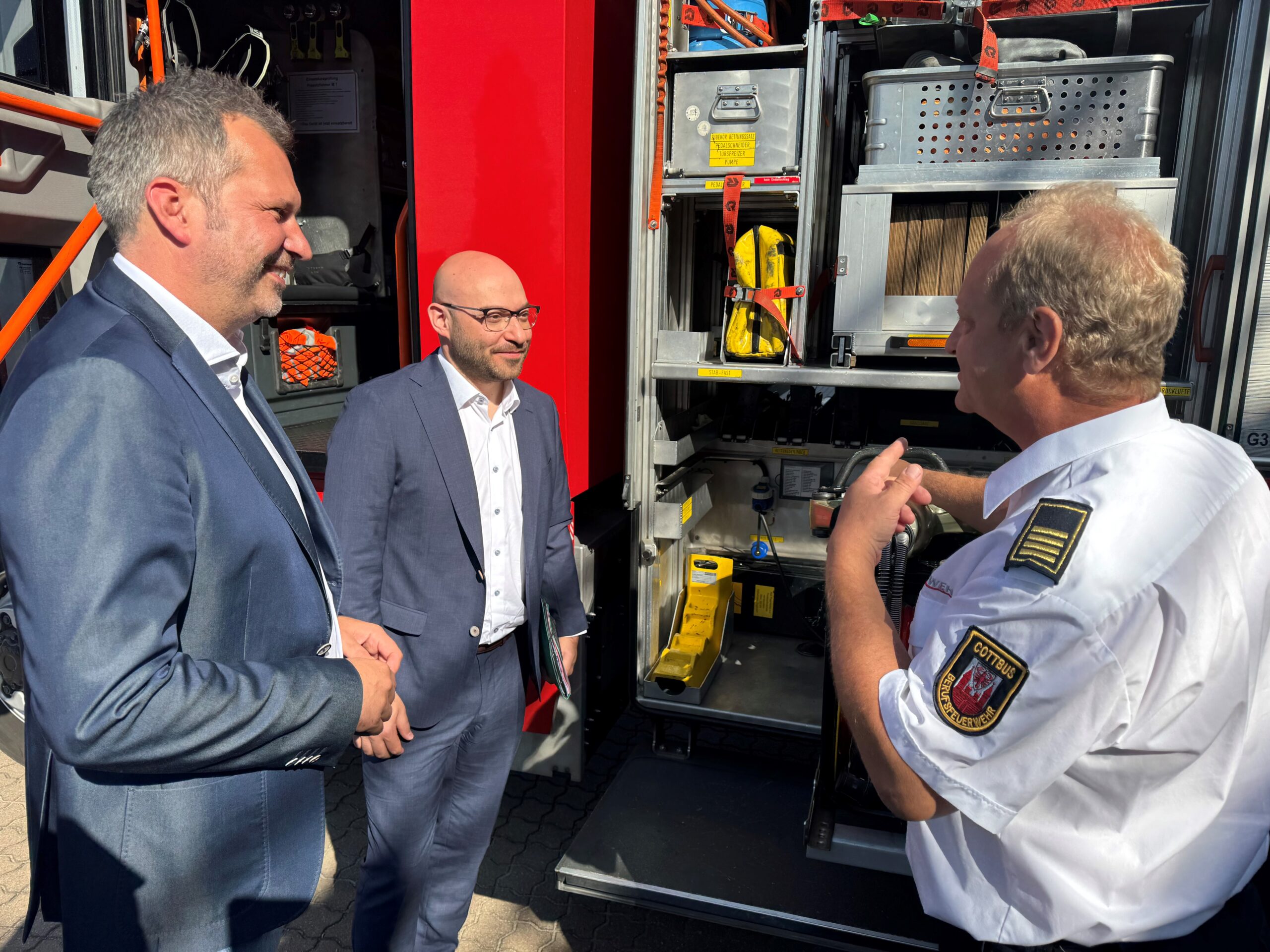 PM_OB_MIK_Wilke_Feuerwehr Auf dem Hold schauen sich Cottbus Oberbürgermeister und Brandenburgs Innenminister ein Feuerwehrauto an
