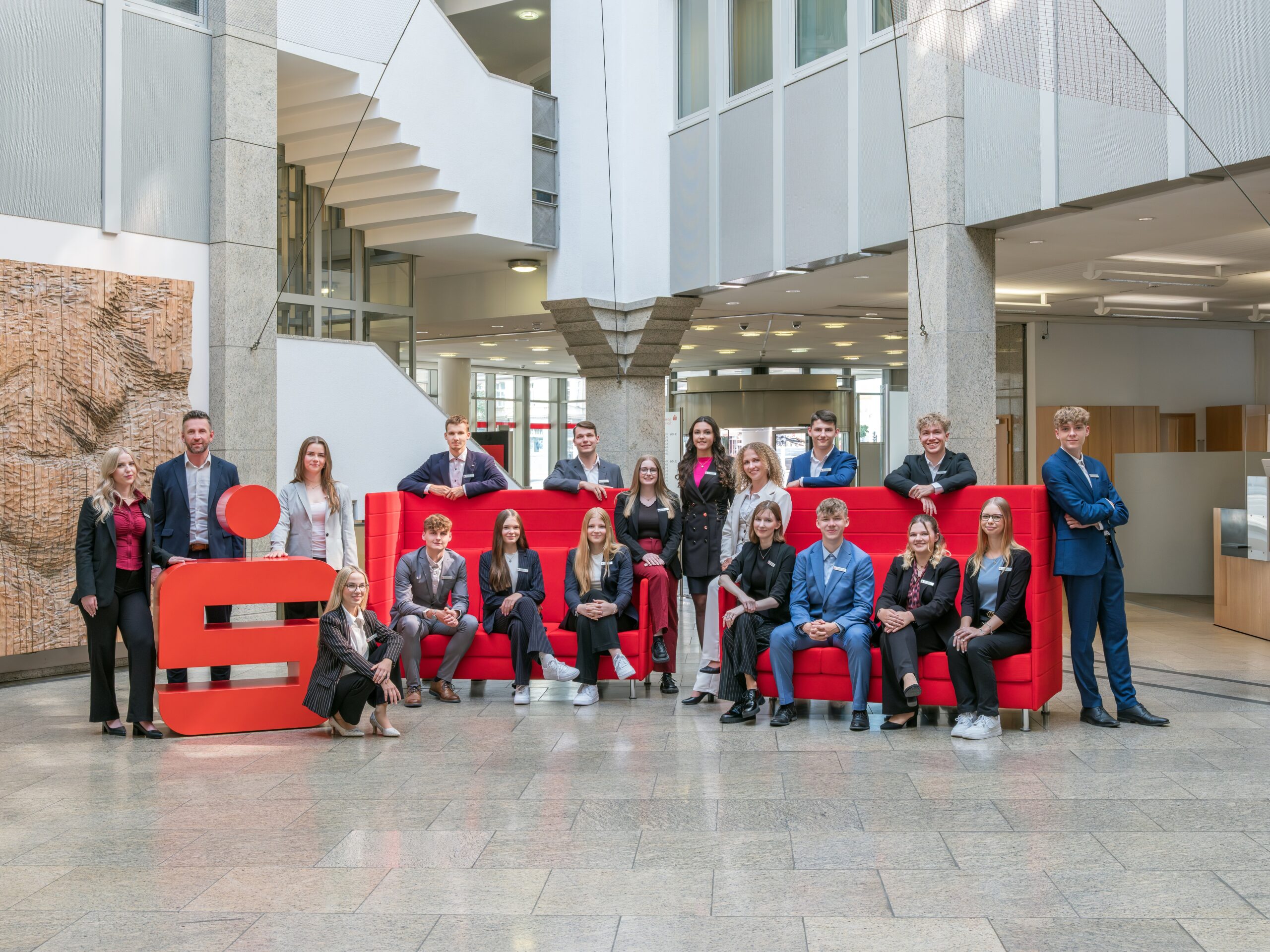 Junge Menschen stehen in der Hauptfiliale der Sparkasse Spree-Neiße