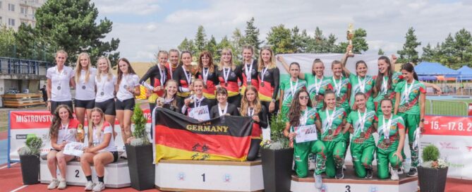 Frauen halten Medaillen hoch