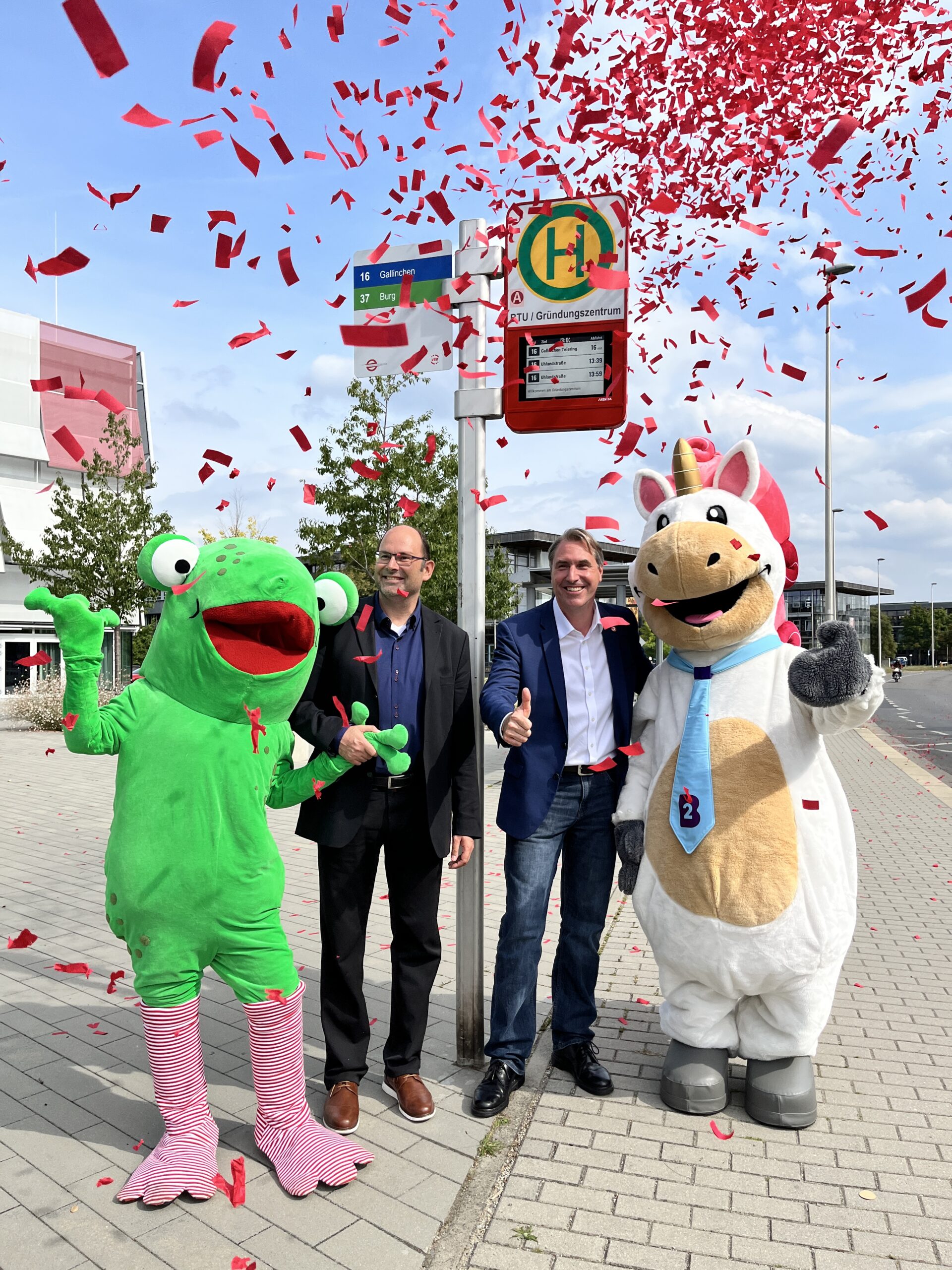 Zwei Maskottchen weihen eine Haltestelle ein