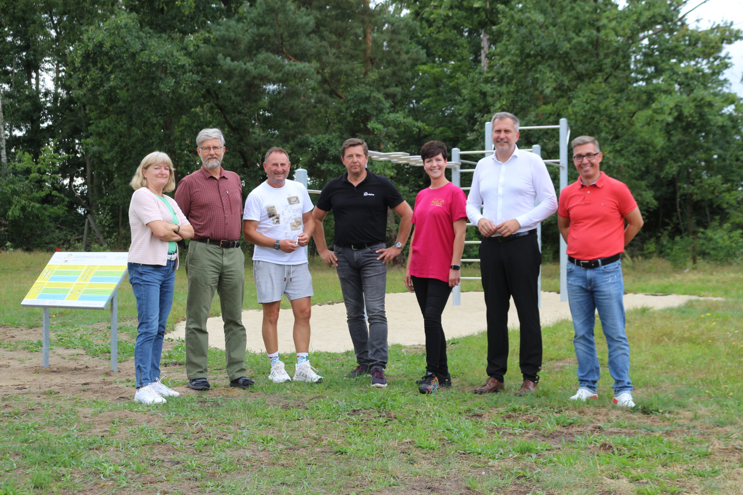 Spielgeräte_Branitz Menschen stehen vor einem Spielplatz