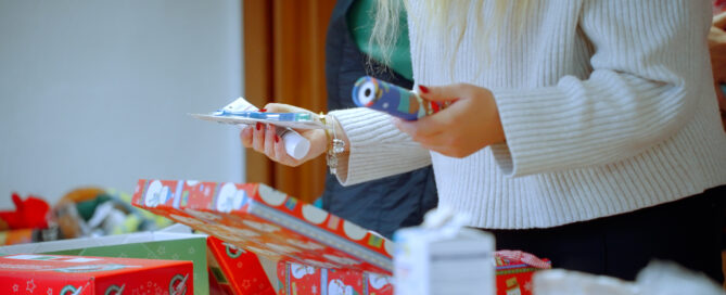 Eine Person packt ein Päckchen für die Aktion "Weihnachtsfreude im Schuhkarton"