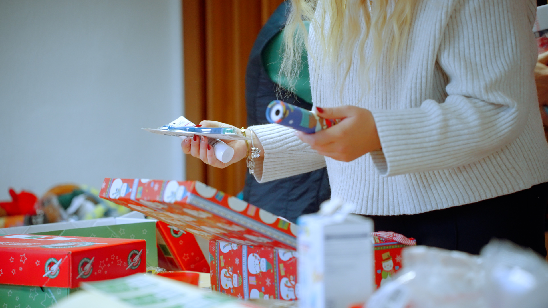 Weihnachten_im_Schuhkarton Eine Person packt ein Päckchen für die Aktion "Weihnachtsfreude im Schuhkarton"