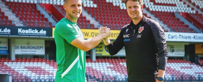 Torwart und Torwarttrainer stehen im Stadion