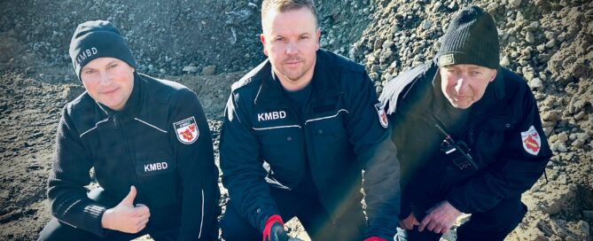 Männer hocken vor einer entschärften Bombe