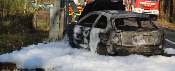 Ein Auto ist abgebrannt und wird mit Schaum gelöscht