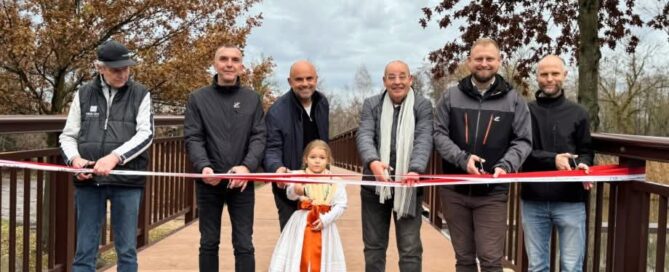 Menschen stehen nebeneinander und schneiden ein Band durch