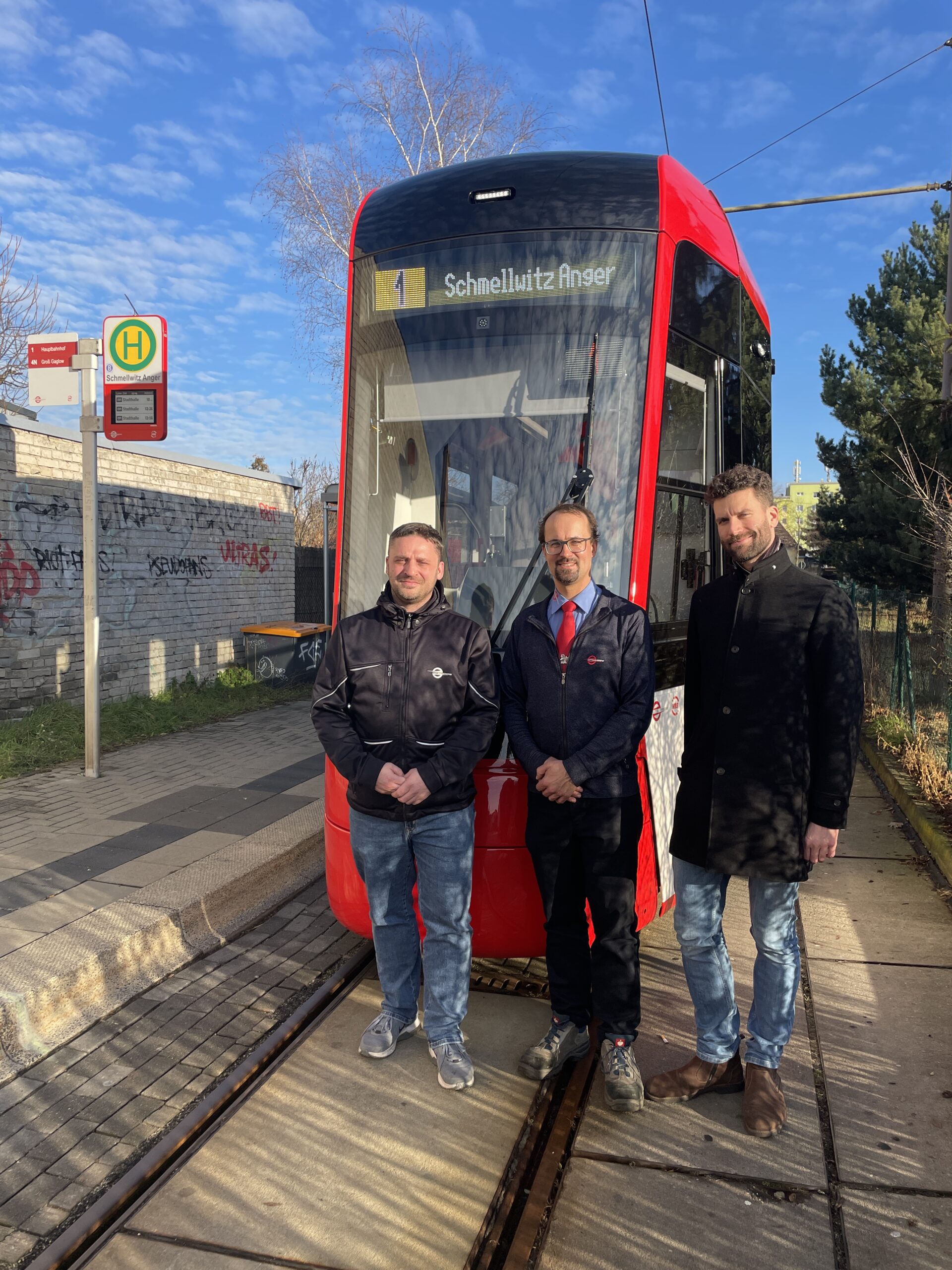 IMG_4804 Menschen stehen vor einer Straßenbahn