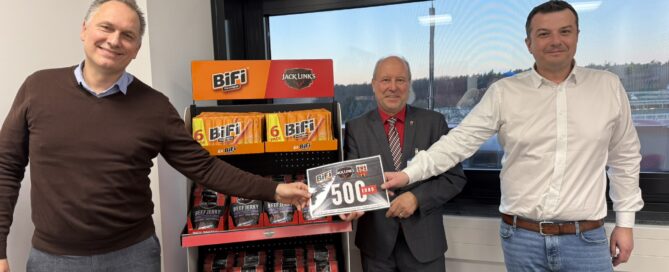 Gubens Bürgermeister hält einen Scheck vor Bifis