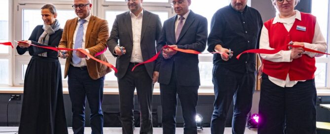 Menschen schneiden ein rotes Band druch