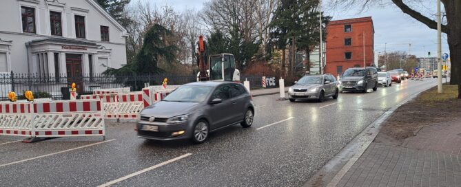 Das Foto zeigt eine Baustelle in der Franz-Mehring Straße mit vorbeifahrenden Autos.