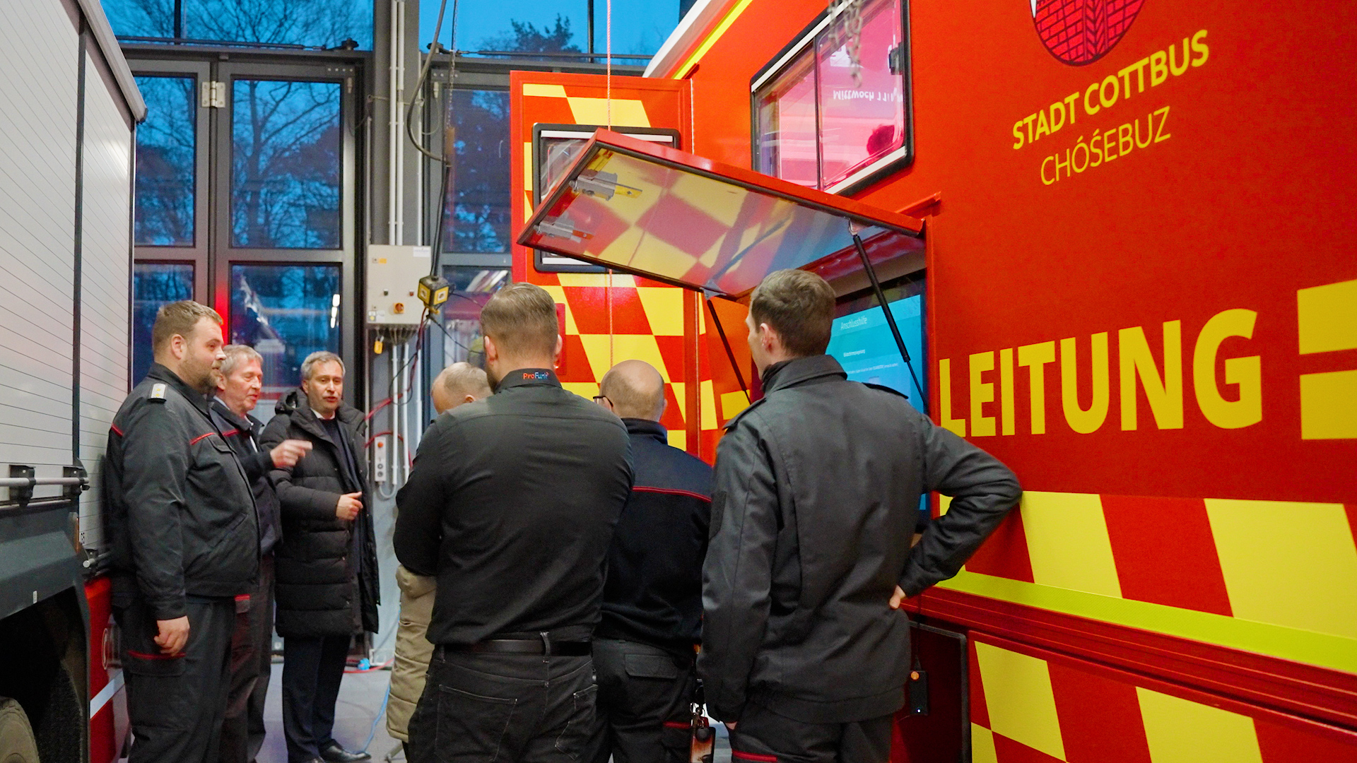 Feuerwehr_Autos Menschen stehen neben einem Feuerwehrauto
