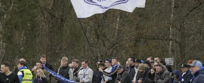 Fußballfans stehen auf dem Platz