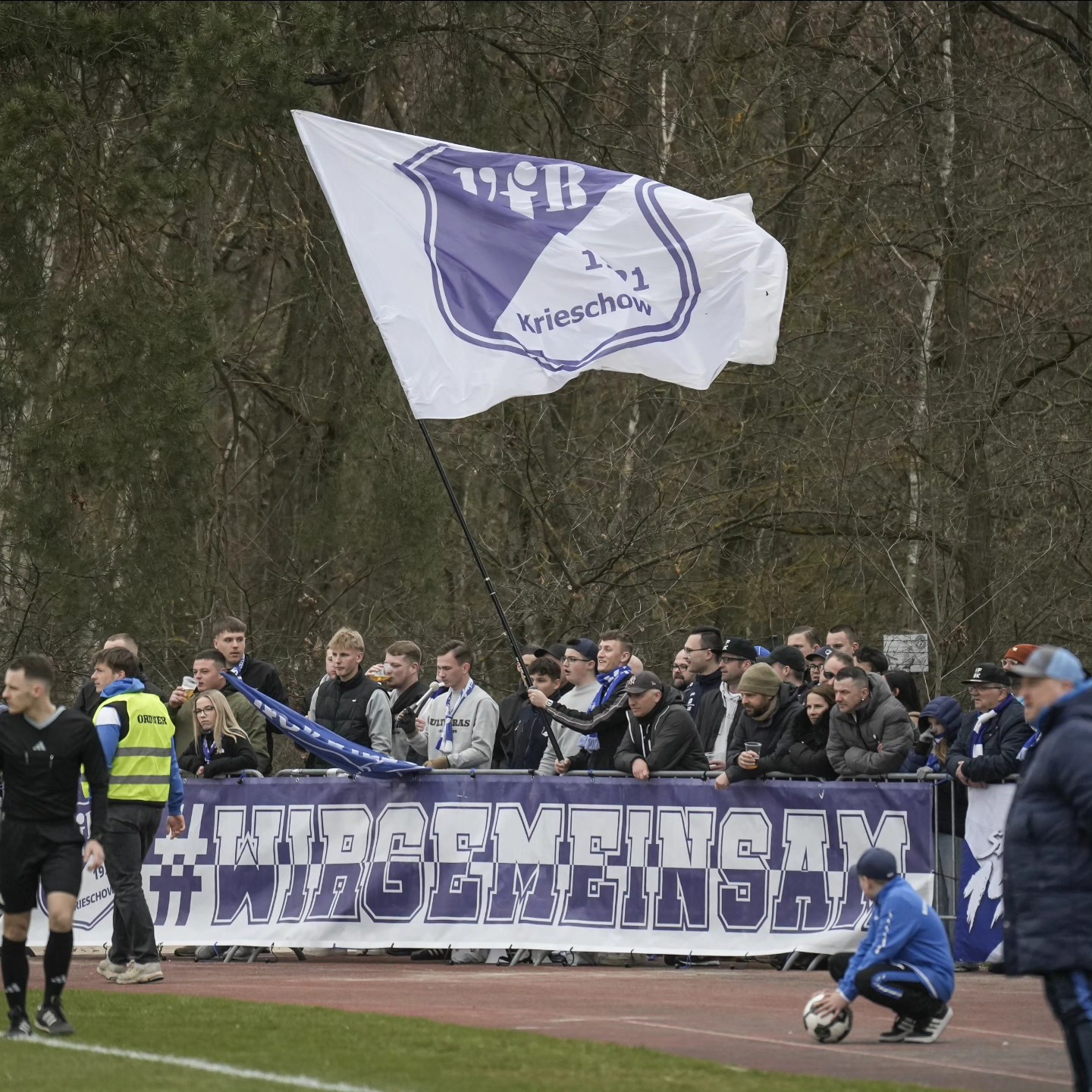Fußballfans stehen auf dem Platz