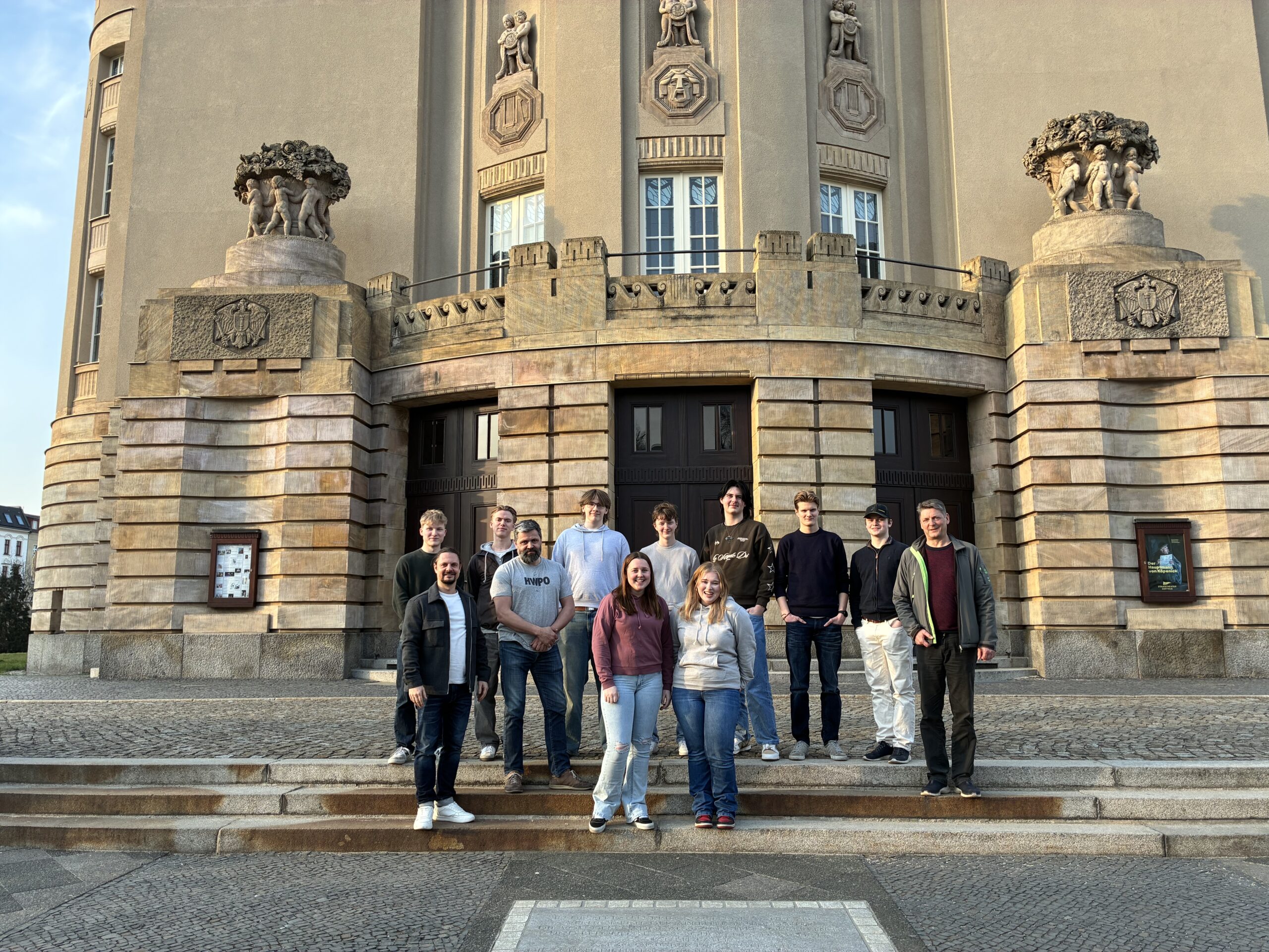 Junge Menschen stehen vor dem Staatstheater Cottbus