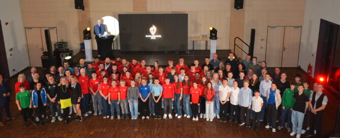 Kinder und Sportler stehen nebeneinander