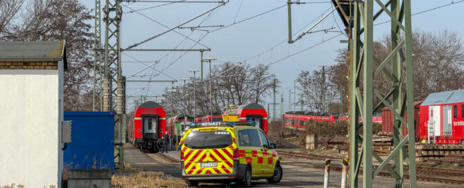 Bahngelände wo ein Zug und ein Notarztwagen stehen